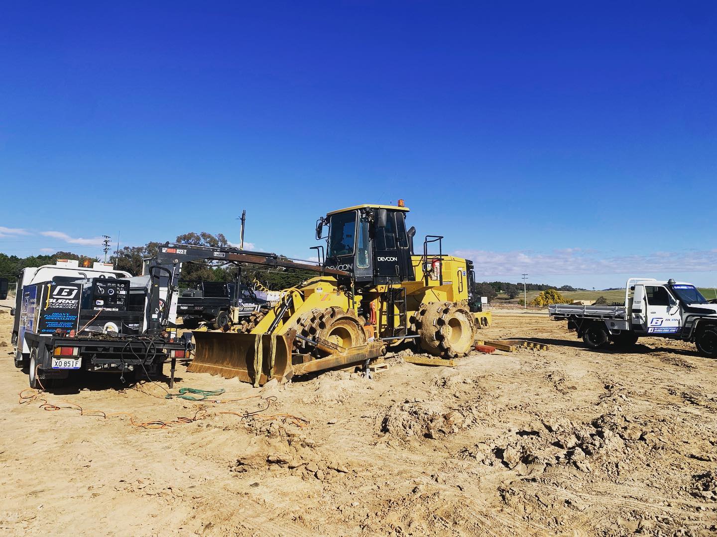 Construction site with machinery and utility trucks.